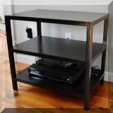 F12. One of a pair of tiered black side tables 26”h x 28”w x 18”d 